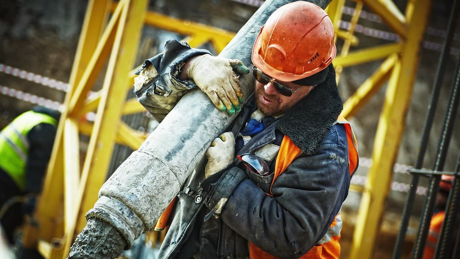 Industriarbetare i skyddsutrustning hanterar timmer